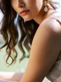 Close-up bridal portrait highlighting earrings, lips and hairstyle during Sunstone Winery wedding morning.