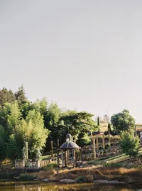 Scenic view of the Italian-inspired winery ceremony location with lake, gardens, and classical columns in Lake Oswego Oregon.