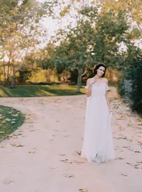 Bride's flowing tulle skirt trailing across a leaf-scattered garden path, a quiet moment from a Santa Barbara wedding editorial by Yuliya Supin Design
