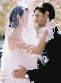 Close embrace between bride and groom, his arm around her lace and tulle gown, an intimate moment from a Santa Barbara wedding editorial by Yuliya Supin Design