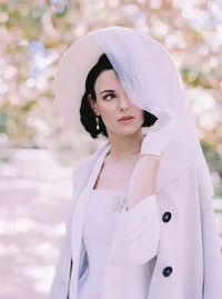 Soft color close-up of a pearl brooch on a cream bridal coat, an editorial styling detail by Yuliya Supin Design in Santa Barbara