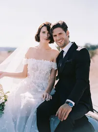 Bride and groom seated close together, her hand resting on his, a tender detail from a Santa Barbara wedding editorial by Yuliya Supin Design