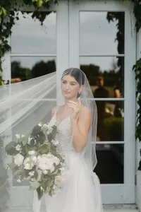 Bride in modern gown and veil holding romantic garden rose bouquet at private estate wedding near Vancouver, Washington.