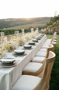 Side-angle close-up of glassware, dinnerware, and organic floral centerpiece on velvet linen.
