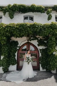 Bride standing in the ivy-covered doorway holding her bouquet, private estate wedding in Vancouver, Washington