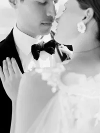 Bride and groom dancing together with flowing veil during romantic vineyard wedding.