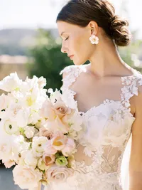 Bride portrait highlighting embroidered gown and floral earrings at Sunstone Winery.
