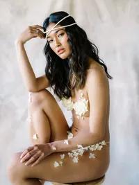 Modern bridal editorial seated on stool with soft sculptural styling