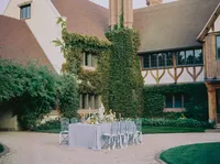 Wide view of the reception table set within an ivy-covered estate courtyard, from a Santa Barbara wedding editorial by Yuliya Supin Design