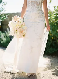 Bridal bouquet and embroidered wedding gown with elegant bridal shoes at Sunstone Winery wedding.