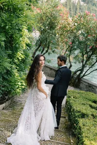 Bride and groom walking on the Historic Hotel Villa Cipressi garden overlooking Lake Como, Italy