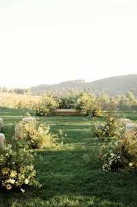 Wide-angle view of ceremony island framed by wild yellow florals and rolling Oregon hills.