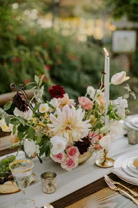 Wedding floral centerpiece with soft peach and ivory blooms on outdoor reception table