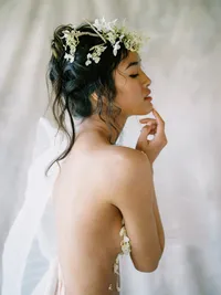 Bridal portrait from behind with veil and floral accents in editorial setting