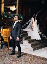 Bride walking down the staircase toward the groom during their first look moment at the historic Nines Hotel in Portland before their Lake Oswego Oregon winery wedding.