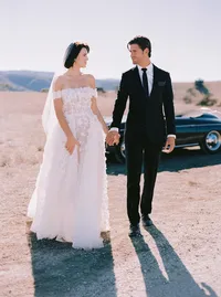 Bride and groom walking side by side across a sunlit path, long shadows trailing behind them, from a Santa Barbara wedding editorial by Yuliya Supin Design