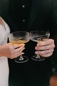 Bride and groom laughing with champagne at reception table during private estate wedding in Vancouver, Washington.