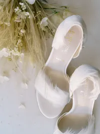 Bridal shoes styled with soft florals and neutral textures in editorial setting