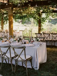 Long reception table under an ivy-covered pergola with elegant chairs, candles, and floral centerpieces at a romantic Portland garden wedding near Lake Oswego Oregon.