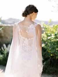 Back view of bride’s gown and veil cascading from shoulders during Sunstone Winery wedding portrait.
