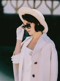 Close-up of a pearl Chanel-style brooch pinned to a cream bridal coat, a refined styling detail from a Santa Barbara wedding editorial by Yuliya Supin Design