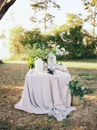 Outdoor wedding table with linen and organic decor in natural landscape