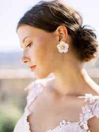 Bride portrait highlighting embroidered gown and floral earrings at Sunstone Winery.