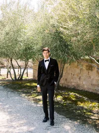 Groom portrait standing among olive trees at Sunstone Winery vineyard wedding in Santa Ynez.