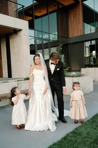 Bride sharing a quiet moment holding hands with two flower girls just before the ceremony.