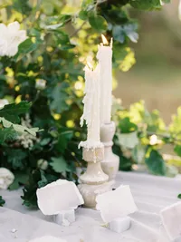 close-up of candle and handmade paper on wedding table with soft textures