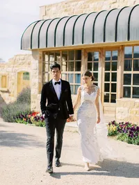 Bride and groom holding hands walking toward reception after ceremony at Sunstone Winery vineyard wedding.