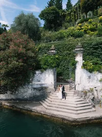 Editorial wedding styling of bride and groom in historic Italian villa Cipressi gates