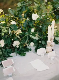 Wedding table styling with handmade paper, candle, and natural floral arrangement
