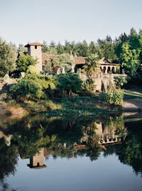 Scenic view of an Italian-inspired winery estate with lake and vineyard landscape during a Lake Oswego Oregon garden wedding.