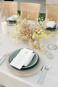 Detailed reception table styling captured from a secondary angle highlighting layered textures and floral design.