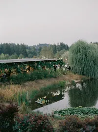 Wide landscape view of the Italian-inspired winery estate with lake, gardens, and reception tent in Lake Oswego Oregon.