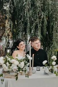 Bride and groom laughing with champagne at reception table during private estate wedding in Vancouver, Washington.