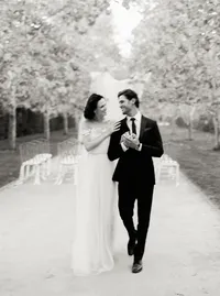 Black-and-white view of the newlyweds walking arm in arm up the ceremony aisle, from a Santa Barbara wedding editorial by Yuliya Supin Design