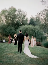 Bride and groom walking hand in hand toward the reception celebration at their Lake Oswego Oregon winery wedding.