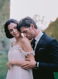 Groom's arm wrapped around the bride's off-shoulder floral sleeve, a close embrace from a Santa Barbara wedding editorial by Yuliya Supin Design