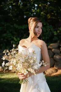 Bride holding a delicate wildflower bouquet before ceremony at Lucid Wild Vineyard estate.