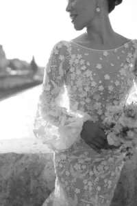 Black and white portrait of the bride standing on a Paris bridge near the Seine River.