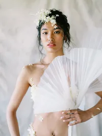 Bridal editorial with sculptural fan and soft draping textures