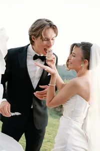 Sculptural wedding cake displayed against Lucid Wild vineyard landscape with open sky behind.