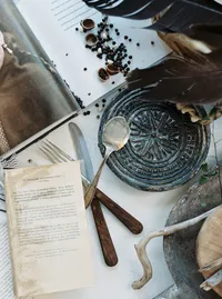 Styled flatlay with book, utensils, and natural elements for wedding editorial