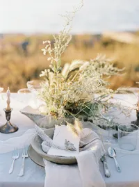 Delicate white floral arrangement on wedding table with layered textures