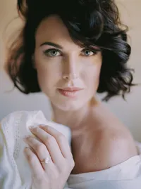 Bride with soft waves in an off-the-shoulder gown, resting her chin on her hand, from a Santa Barbara wedding editorial by Yuliya Supin Design