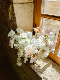 Bridal bouquet resting by window light inside Sunstone Winery stone villa.