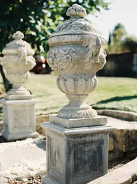 Italian-inspired ceremony entrance featuring large stone urns and classic architecture at a romantic Lake Oswego Oregon winery wedding.