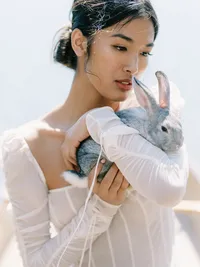 Bridal editorial portrait holding rabbit symbolizing softness and emotion in nature